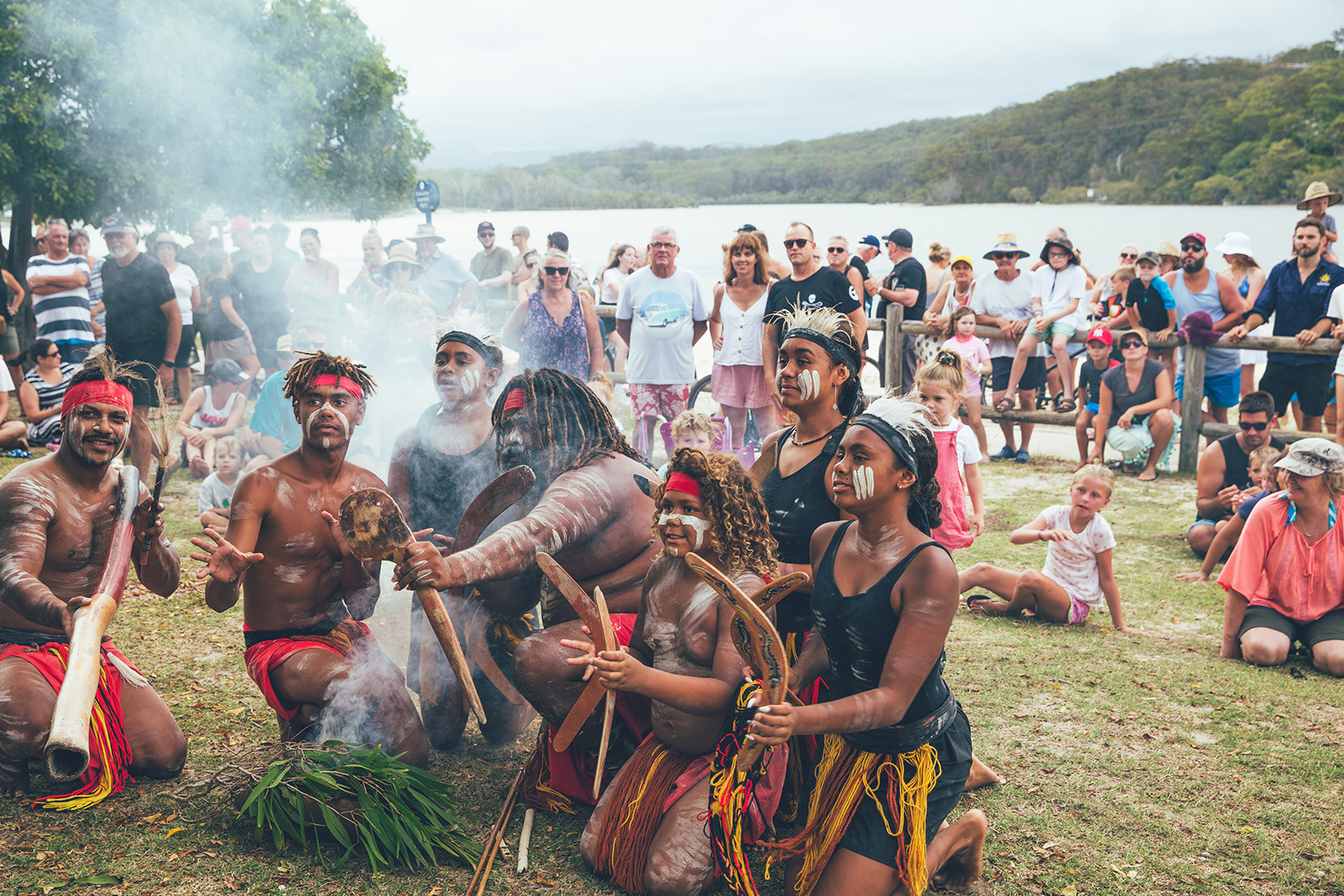 Aboriginal dancers posing at a smoking ceremony at Tallebudgera Creek Tourist Park. Guests of the park watching in the background.