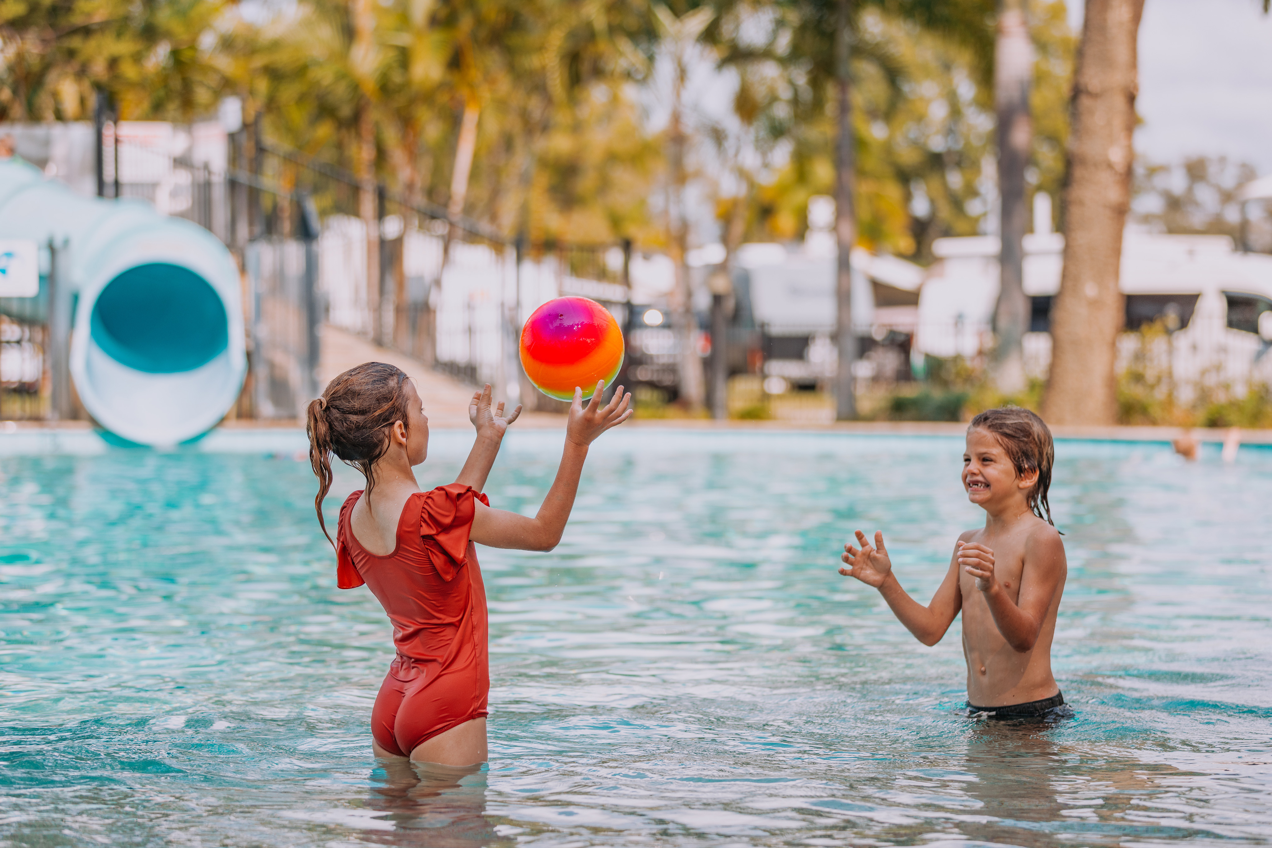 Two young kids playing with a ball in the kids pool at Tallebudgera Creek Tourist Park.