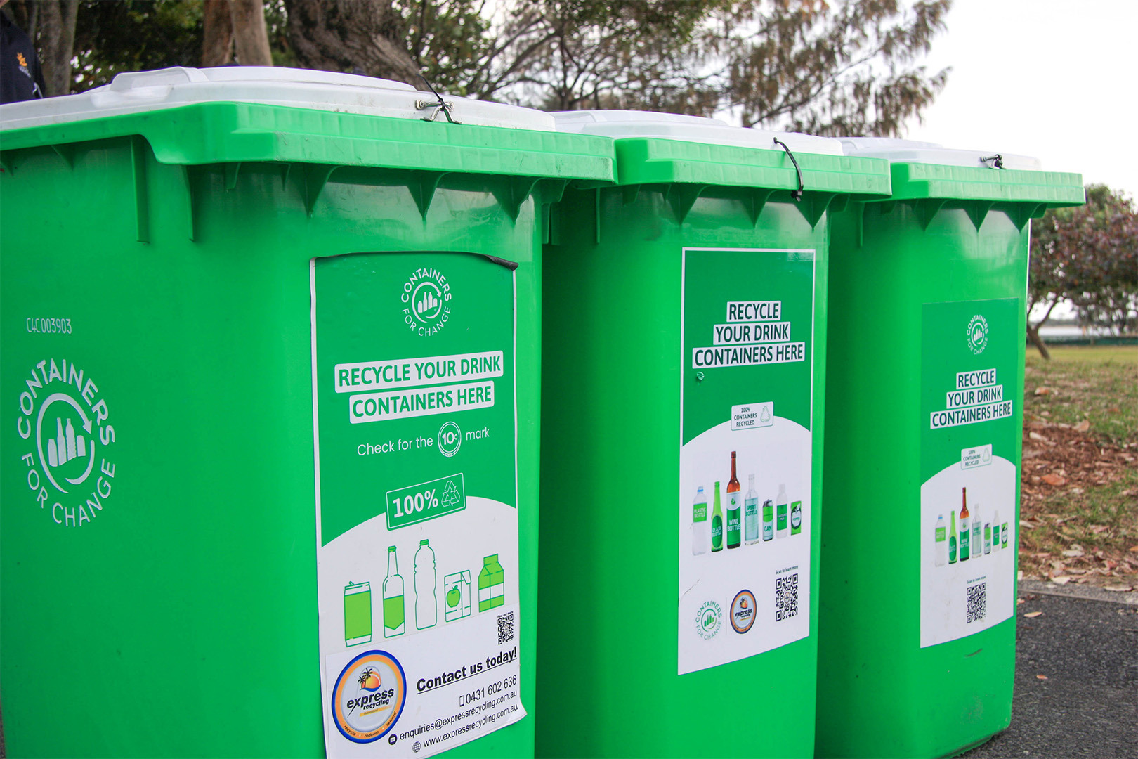 Three green Containers for Change recycling bins.