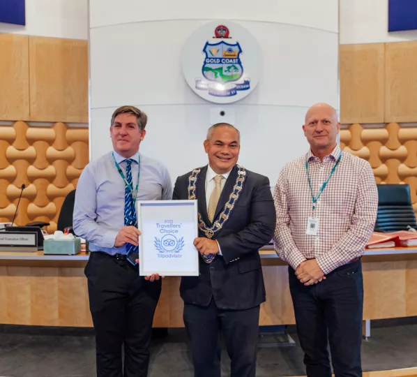 Mayor Tom Tate presenting the TripAdvisor 2022 Travellers’ Choice Award to Manager Community Venues And Services Mr Richard Pascoe and Executive Coordinator Tourist Parks Mr Andrew Illingworth