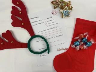 Colourful reindeer antlers, letter to Santa and a Christmas stocking with chocolates