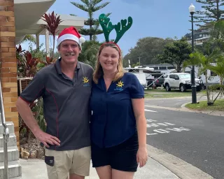 Matt and Laura the Park Managers standing in front of reception with a Santa hat and antlers